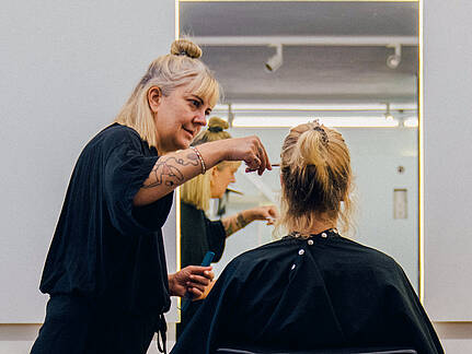 Friseurin Steffi Sch&ouml;ne schneidet einer Kundin in ihrem Salon die Haare