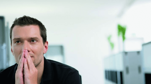 Person mit gefalteten Händen vorm Gesicht